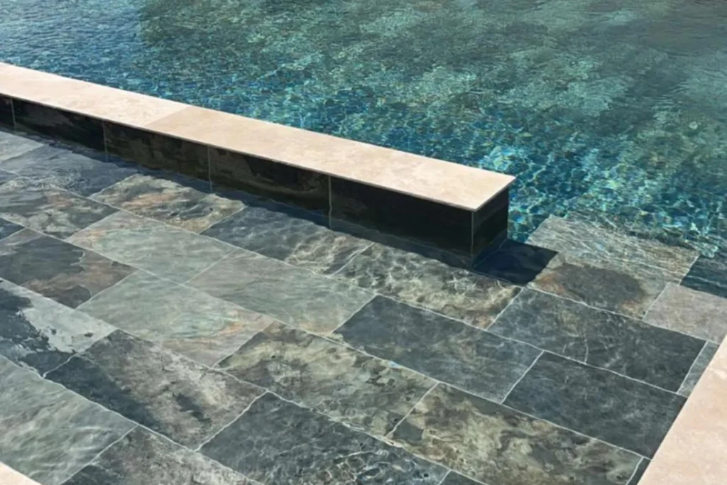 Terrasse de piscine habillée en carrelage Bali effet ardoise multicolore, ambiance naturelle et haut de gamme avec finitions rectifiées.