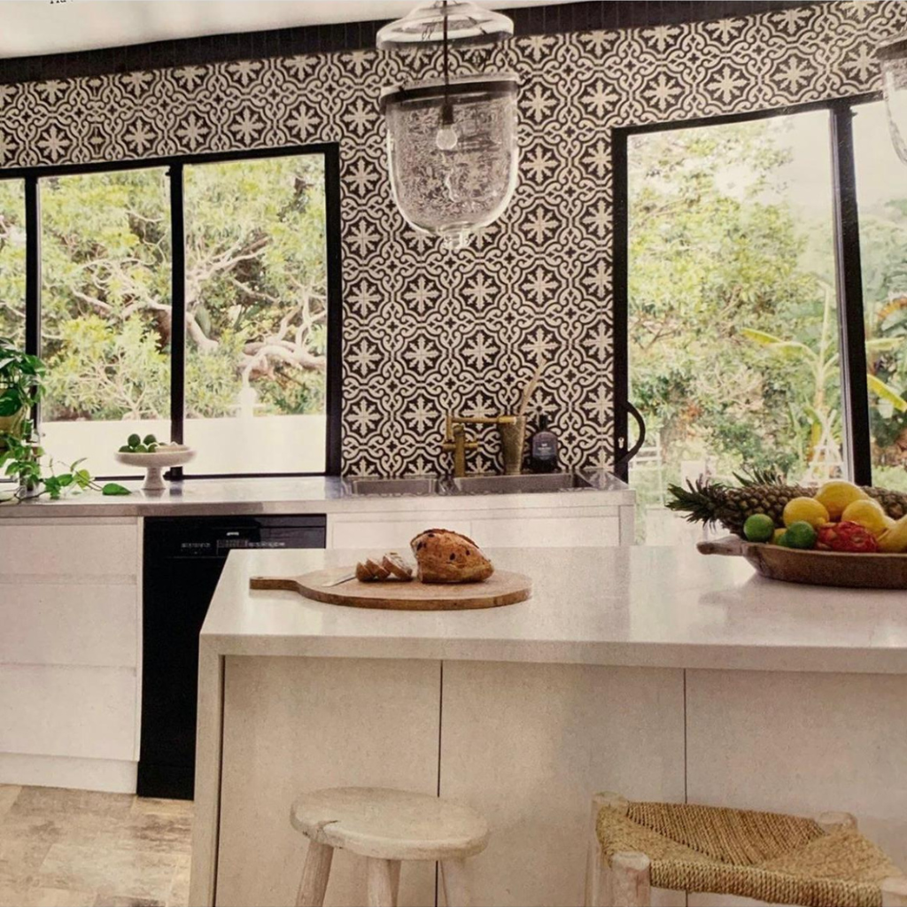 Cuisine lumineuse avec crédence murale en carreaux de ciment noirs à motifs.