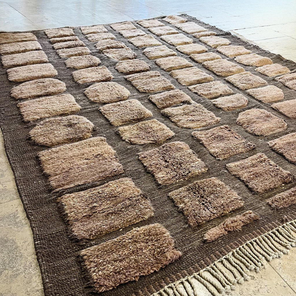 tapis clair en laine avec motifs géométriques en relief et texture épaisse