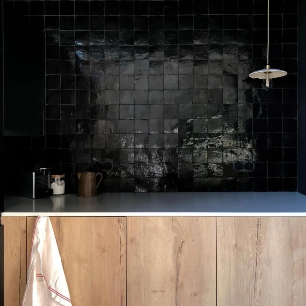 Zellige noir artisanal marocain avec meubles en bois clair, crédence de cuisine moderne.