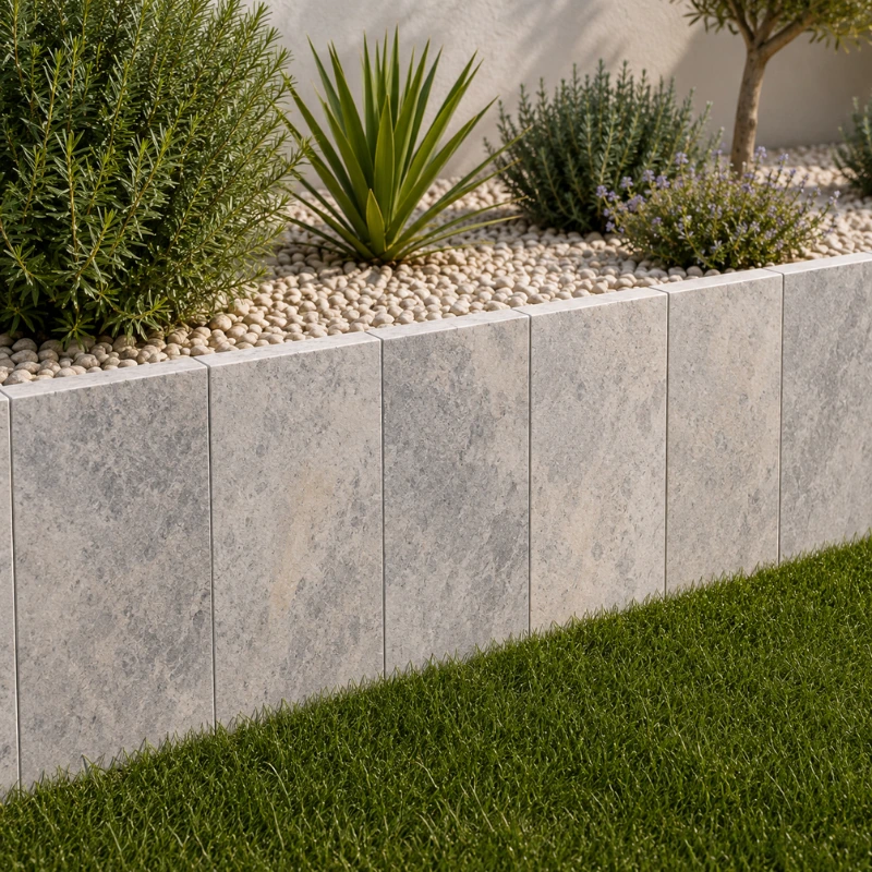 Palis en travertin Silver installés en retenue de terre dans un jardin contemporain.