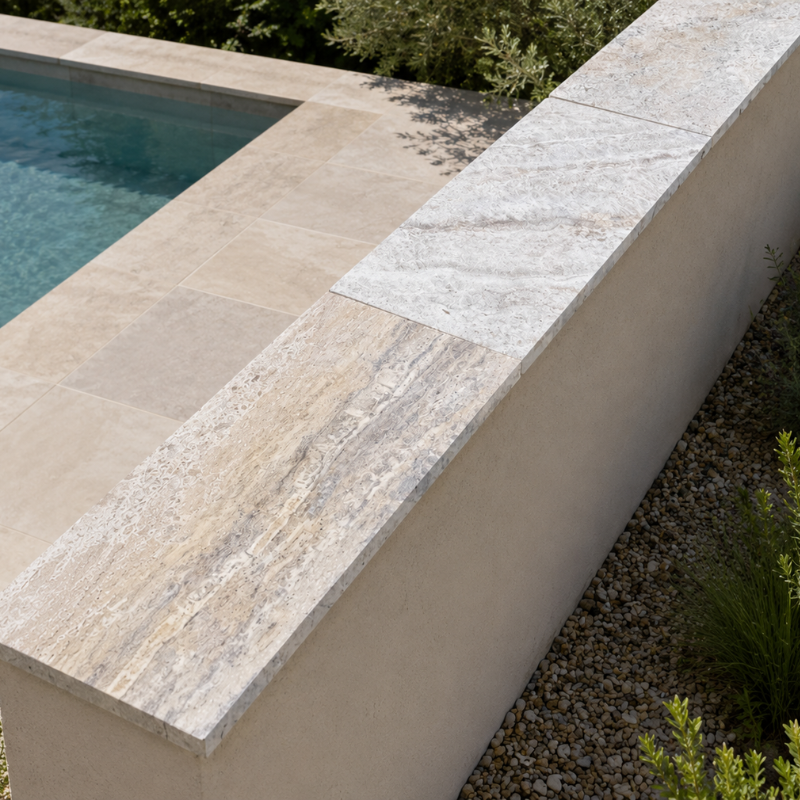Dessus de mur en travertin beige installé sur un muret près d'une piscine.