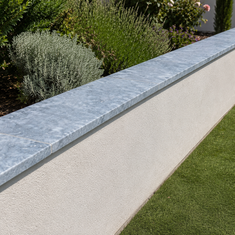 Dessus de mur en pierre bleue naturelle posé sur un muret de jardin avec finition contemporaine.