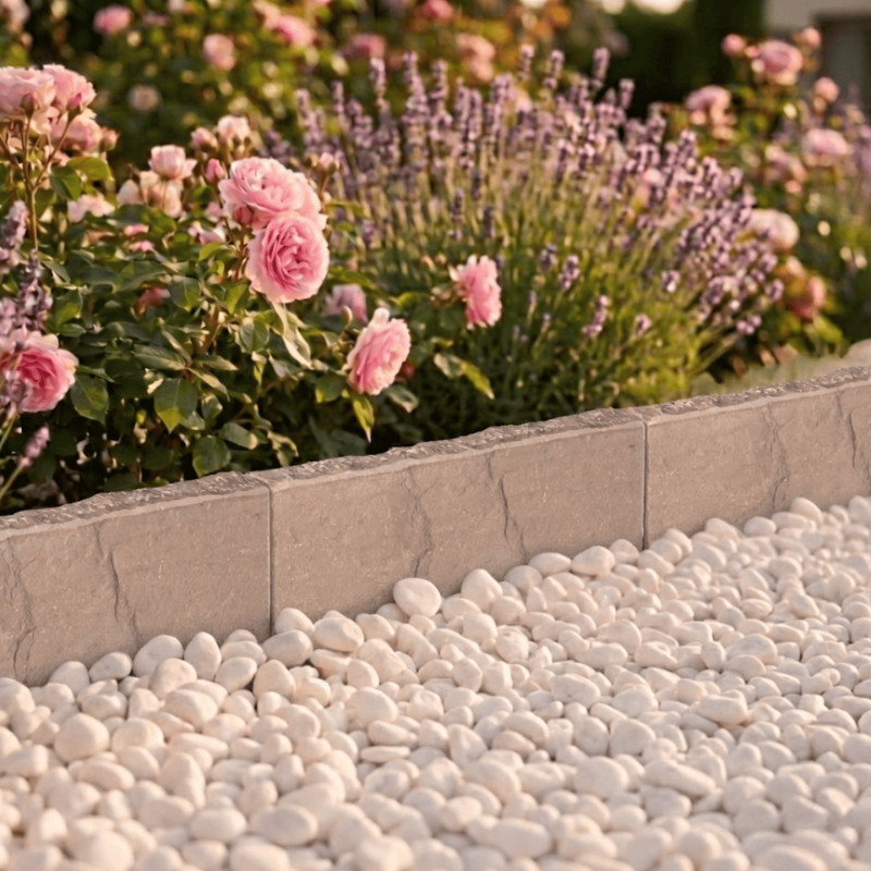 Bordure en Pierre de Kandla beige délimitant un massif fleuri avec gravier décoratifi
