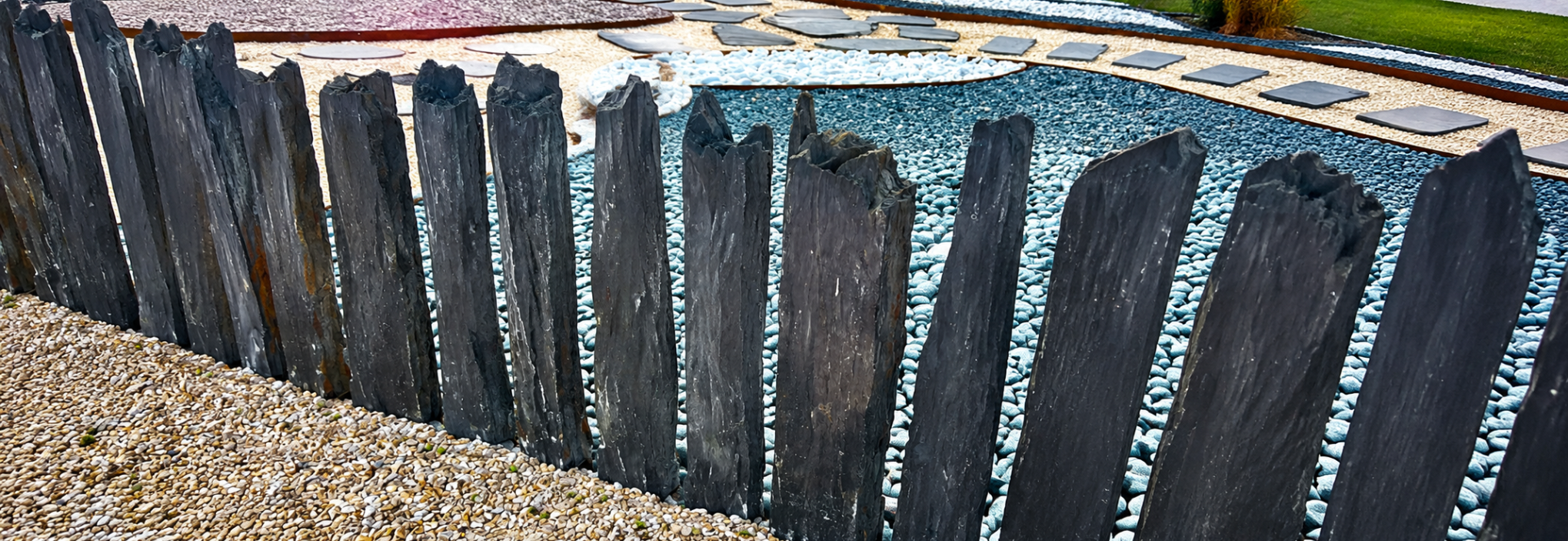 Piquets en schiste naturel posés en bordure de jardin avec galets décoratifs et pas japonais