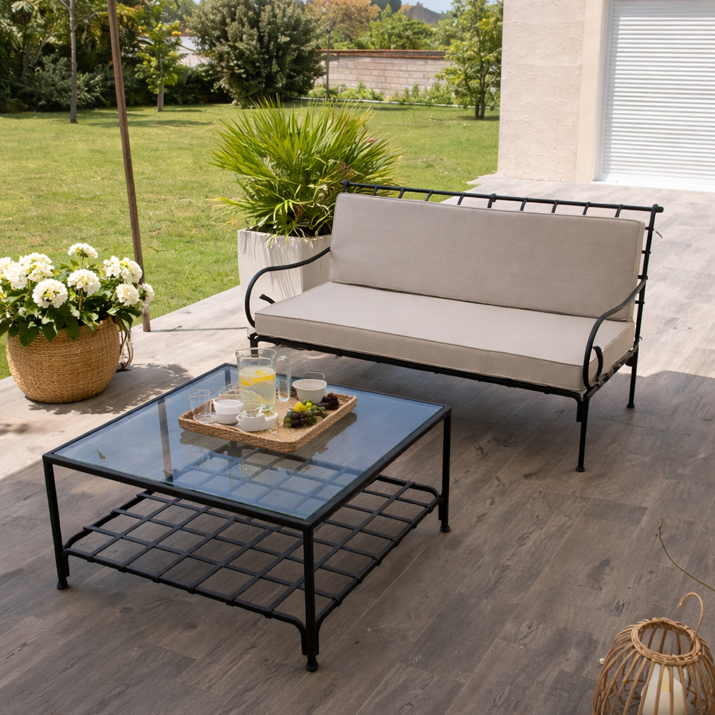 Chaise en fer forgé élégante avec coussin clair, installée sur une terrasse lumineuse avec décor méditerranéen et table de café.